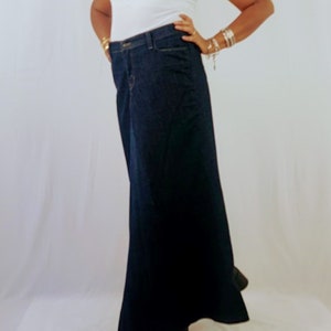 May include: A dark blue denim maxi skirt with a straight fit and a slight flare at the bottom.