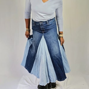 May include: A long denim skirt with a patchwork design. The skirt is made of different shades of blue denim and has a flared silhouette.