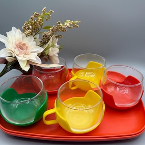 Vintage 1960-talsset med 5 Melitta kaffe- eller tekoppar med färgglada plasthållare - 2 serveringsbrickor gröna gul-orange koppbrickor
