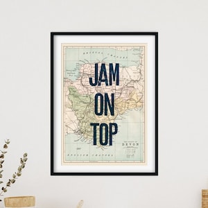 May include: A framed print featuring a vintage map design with the text "JAM ON TOP" in bold blue lettering.