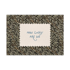 K&ouml;nnte beinhalten: Rechteckige Gru&szlig;karte mit cremefarbenem, gezacktem Mittelteil. Der Text in der Mitte lautet "HOW LUCKY ARE WE" in blauer Schrift. Der Kartenrand zeigt ein sich wiederholendes Muster aus gr&uuml;nen Bl&auml;ttern auf schwarzem Hintergrund.