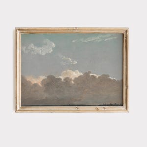 May include: A framed landscape painting shows a cloudy sky in shades of blue, grey, and brown. The artwork features a detailed depiction of clouds and a horizon line, encased in a gold-toned wooden frame. The painting evokes a sense of tranquility.