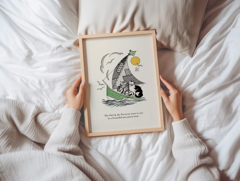 May include: A framed art print featuring a whimsical illustration of cats sailing in a green boat. The artwork includes a patchwork sail, a yellow sun, and the text "The Owl & the Pussycat went to sea, in a beautiful pea green boat."