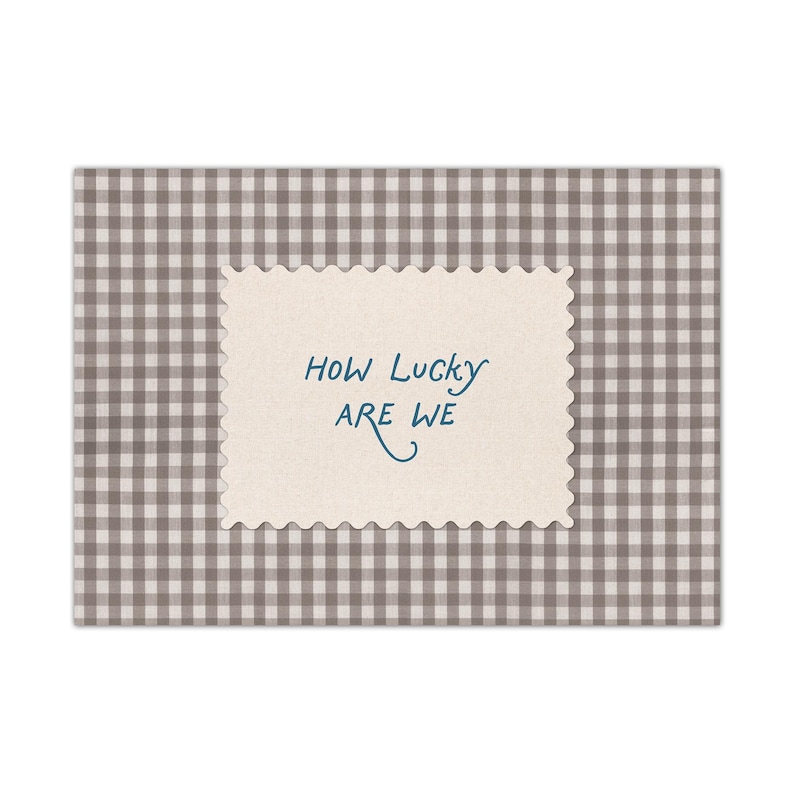 K&ouml;nnte beinhalten: Eine Gru&szlig;karte mit beigefarbenem, gezacktem Rand, die den Text "HOW LUCKY ARE WE" in blauer Schrift tr&auml;gt. Die Karte ist vor einem grau-wei&szlig; karierten Hintergrund platziert, was ein schlichtes und elegantes Design ergibt.