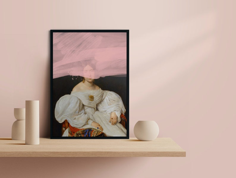 May include: A framed print of a woman in a white dress with a pink abstract design overlaying her face. The background is dark.