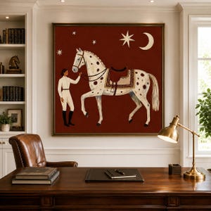 May include: A square wall art print featuring a white horse with dark spots and a brown saddle standing on a deep red background. A person in white equestrian attire holds the horse's reins. The scene includes a white crescent moon and stars.