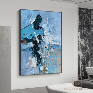 Pu&ograve; includere: Dipinto astratto con pennellate blu, bianche e nere. Il dipinto &egrave; incorniciato in una cornice nera e appeso a una parete bianca.