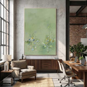 May include: Large framed abstract painting with a light green background. The artwork features delicate lines and soft colors, depicting a pond scene with water lilies and reeds. The painting is displayed in a modern office setting.