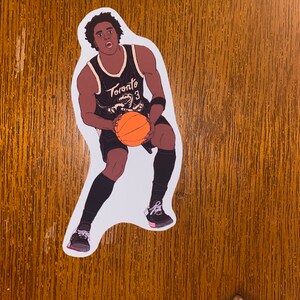 May include: A black and white illustration of a basketball player wearing a black jersey with the word "Toronto" and the number "3" on it. The player is dribbling an orange basketball.