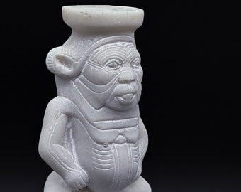 May include: White alabaster statue of a seated figure with a headdress and hieroglyphics on the base.