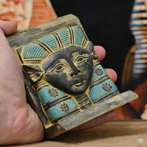 The head of the unique ancient Egyptian goddess Hathor hangs on the wall, large and heavy, made in Egypt