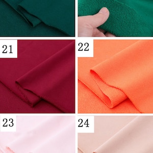 May include: Four different colors of fabric swatches. The swatches are arranged in a grid of four squares. The top left swatch is a dark green, the top right swatch is a lighter green, the bottom left swatch is a dark red, and the bottom right swatch is a light orange.
