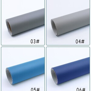 May include: Four samples of upholstery fabric rolled up. The first two samples are a light gray color. The third sample is a light blue color. The fourth sample is a dark blue color. The samples are labeled 03#, 04#, 05#, and 06#.