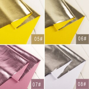 Op de afbeelding: Vier stofstalen van metallic stof in verschillende kleuren. De stalen zijn dubbelgevouwen en tonen de textuur en glans van de stof. De kleuren zijn goud, zilver, roze en een lichter zilver. De stalen zijn genummerd 05, 06, 07 en 08.