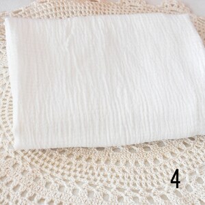 Puede incluir: Tela de algod&oacute;n blanca con una superficie texturizada. La tela est&aacute; doblada y colocada sobre una superficie de crochet. El n&uacute;mero 4 es visible en la esquina inferior derecha de la imagen.