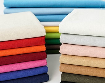 May include: Stacks of folded fabric in various colors, including blue, white, red, orange, pink, and brown. The fabric appears to be a medium weight cotton or linen, suitable for sewing projects. The image showcases a range of hues, from light pastels to vibrant shades.