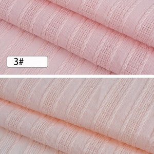 K&ouml;nnte beinhalten: Nahaufnahme eines rosa Stoffes mit strukturiertem Streifenmuster. Der Stoff ist in zwei Lagen gefaltet. Die Zahlen "3#" und "4#" sind auf dem Bild sichtbar.