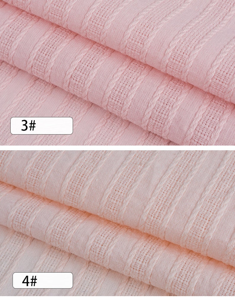 K&ouml;nnte beinhalten: Nahaufnahme eines rosa Stoffes mit strukturiertem Streifenmuster. Der Stoff ist in zwei Lagen gefaltet. Die Zahlen "3#" und "4#" sind auf dem Bild sichtbar.