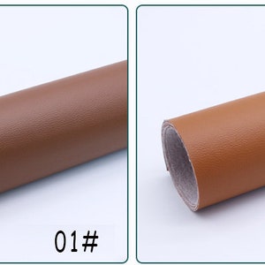 May include: Two rolls of brown faux leather fabric. The roll on the left is a darker brown and the roll on the right is a lighter brown. The rolls are labeled 01# and 02#.