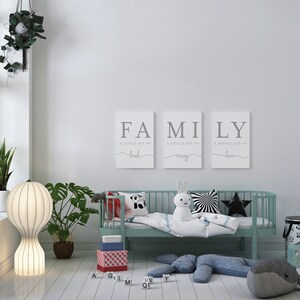 K&ouml;nnte beinhalten: Ein hellblaues Kinderbett mit einer wei&szlig;en Decke und einem Stoffhasen. An der Wand hinter dem Bett h&auml;ngen drei Leinw&auml;nde mit dem Wort "FAMILY" und einem Spruch &uuml;ber Liebe, Verr&uuml;cktheit und Last.