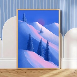 May include: A framed art print featuring a winter landscape with snow-covered mountains and evergreen trees. The artwork uses a palette of blue, pink, and purple hues, with a soft, textured appearance. The print is displayed in a wooden frame.