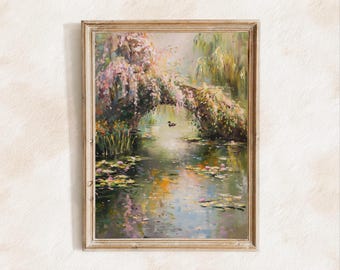 Puede incluir: Una pintura al óleo enmarcada representa una serena escena de estanque con un pequeño puente cubierto de follaje rosa y verde. Los nenúfares flotan en el agua, y un pequeño pato nada en el centro. El marco es de madera clara natural.