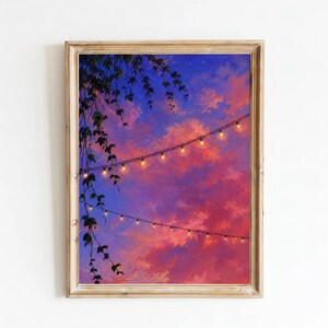May include: A framed wall art print depicting a vibrant sunset sky in shades of purple, pink, and orange. Two strings of glowing fairy lights stretch diagonally across the frame, while dark green ivy leaves hang down from the upper left corner.