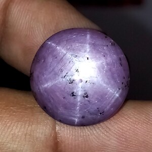 Könnte beinhalten: Ein runder, violetter Stern-Saphir-Edelstein mit einem sechszackigen Stern in der Mitte.