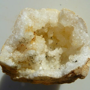 以下が含まれることがあります： 白い外側と、小さな白い結晶で覆われた空洞の内側を持つジオード