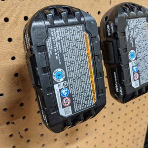 May include: A black Ryobi 18V lithium-ion battery with a warning label and a recycling symbol. The battery is labeled "PBP002" and has a capacity of 1.5 Ah. The battery is made in China.