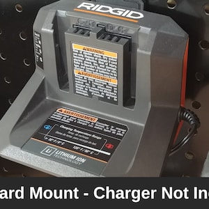 May include: A black and orange pegboard mount for a Ridgid charger. The charger is not included. The mount has a label that says "Lithium Ion Technology".
