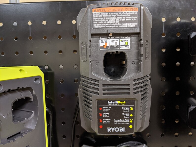 May include: A black and gray Ryobi battery charger with the text "IntelliPort Technology" and a diagram showing the different battery types it can charge. The charger has a warning label in English, French, and Spanish.