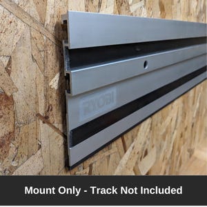 Puede incluir: Un soporte de pared plateado y negro para un sistema de sierra de riel. El soporte está etiquetado con "RYOBI" y el texto "Mount Only - Track Not Included" es visible debajo de la imagen.