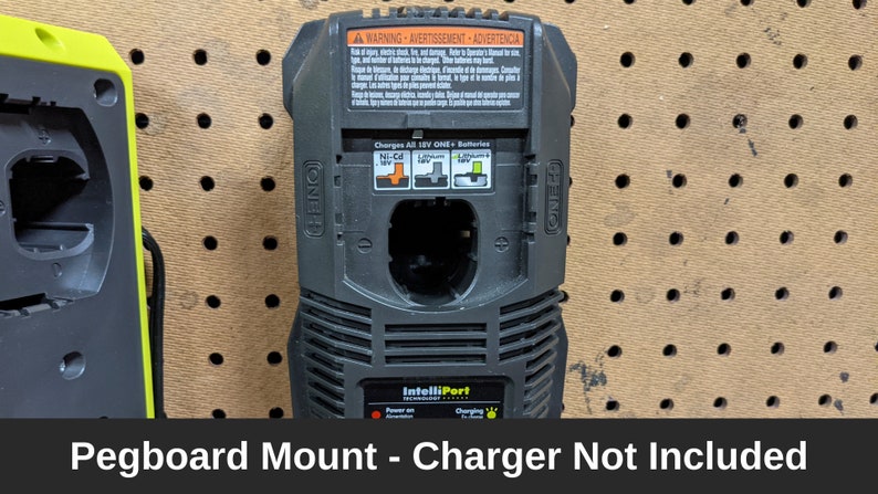 May include: A black pegboard mount for a ONE+ battery charger. The mount has a warning label and says "Charges All 18V ONE+ Batteries". The text "IntelliPort" is visible at the bottom of the mount. The text "Pegboard Mount - Charger Not Included" is visible below the image.