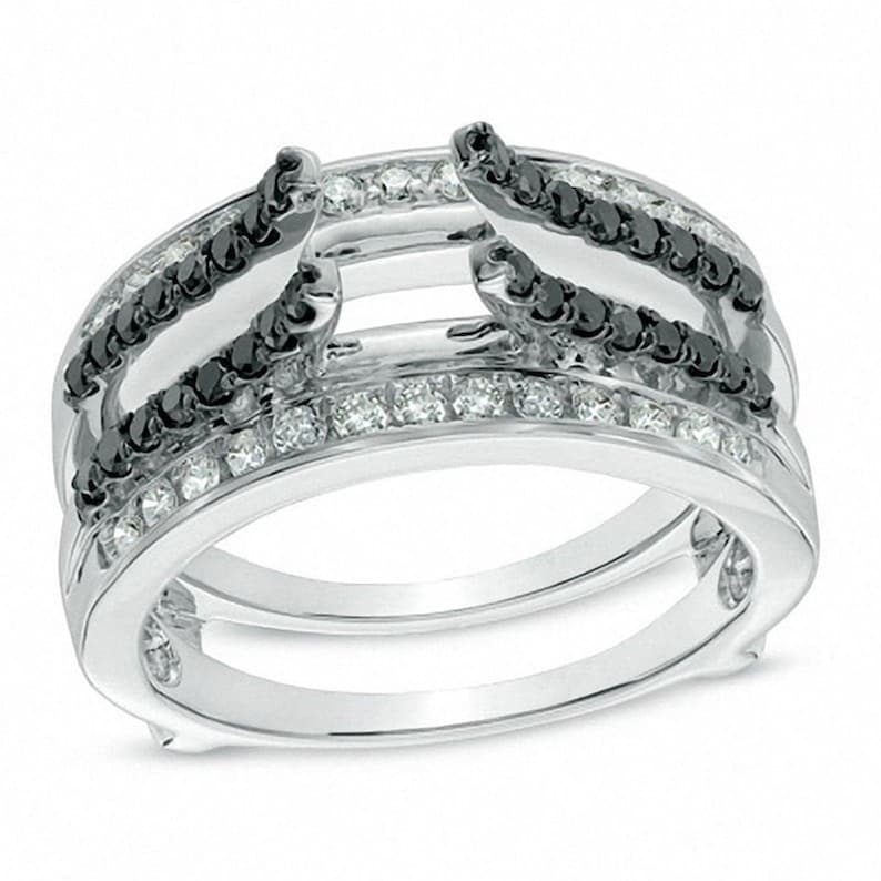 May include: A silver ring with a double band design. The top band features a row of black diamonds and the bottom band features a row of white diamonds.