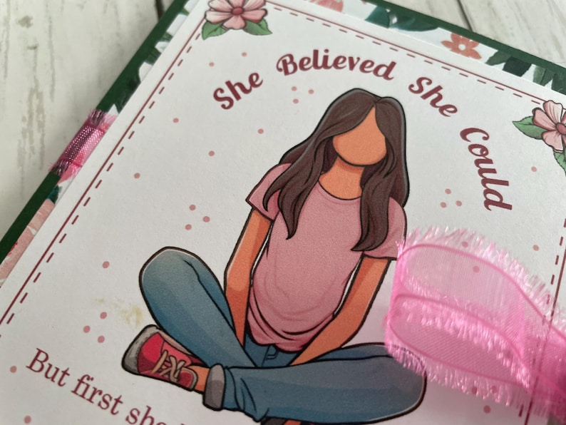 Puede incluir: Una tarjeta rosa y blanca con una ilustraci&oacute;n de dibujos animados de una ni&ntilde;a sentada con las piernas cruzadas. El texto en la tarjeta dice "Ella cre&iacute;a que pod&iacute;a, pero primero ten&iacute;a que creer en s&iacute; misma."