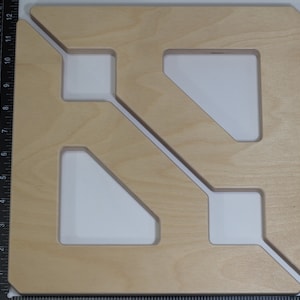 May include: A wooden geometric shape with cutouts, resembling a stylized letter 'N'. The shape is light brown and has a smooth, polished finish.