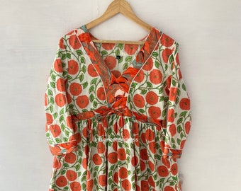 May include: A white cotton dress with a floral print in shades of orange and green. The dress has a V-neckline, 3/4 sleeves, and a gathered skirt. The hemline is trimmed with a ruffle.