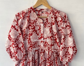 May include: A red and white floral print dress with a mandarin collar and button-down front. The dress has three-quarter sleeves and a gathered waist. The text "indiancottondress" is visible on the dress.