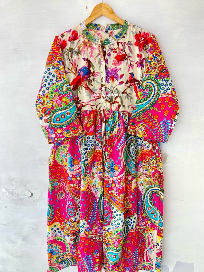 May include: A long-sleeved, colorful dress with a paisley print. The dress has a button-up front and a gathered waist. The fabric is a blend of cotton and silk.