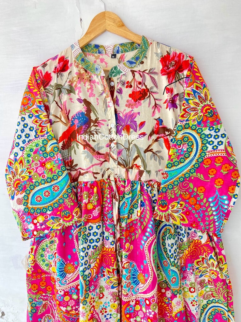 May include: A colorful, floral print dress with a button-up front and long sleeves. The dress has a paisley pattern on the bottom half and a floral pattern on the top half. The dress is made of cotton and is available in a variety of sizes.