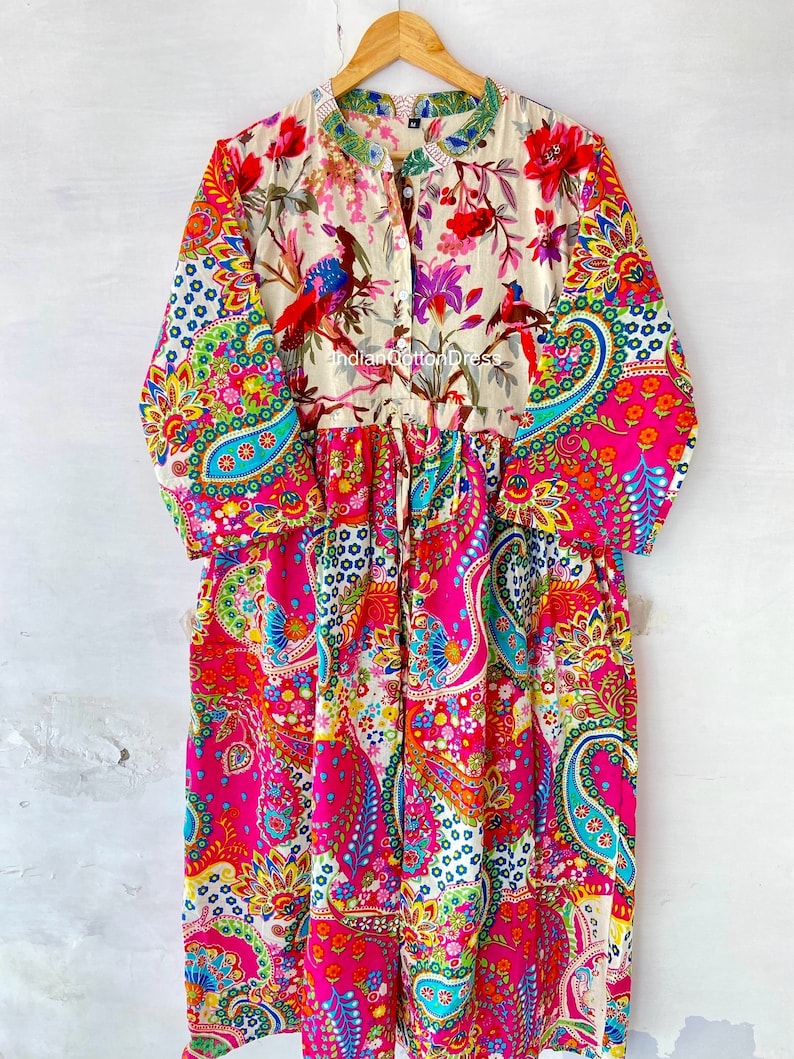 May include: A long-sleeved, colorful dress with a paisley print. The dress has a button-up front and a gathered waist. The dress is made of cotton and is available in a variety of sizes.