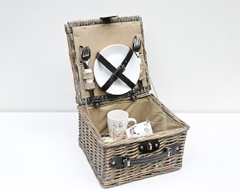 Vintage wicker picnic basket with ceramic tableware. Complete picnic set for 2 persons.