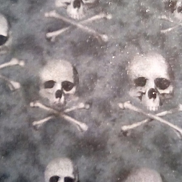 Skulls on a mottled black fabric with glitter in the fabric by Fabric Traditions.