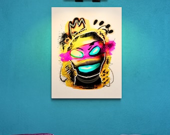May include: A rectangular wall art print featuring a stylized graphic illustration of a head wearing a crown. The artwork uses a vibrant color palette of yellow, hot pink, and bright cyan against a white background with black spray paint accents.