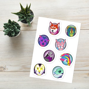 May include: A sticker sheet featuring eight circular illustrations of animals, including a husky, a cat, a rabbit, a bird, a fish, and a lizard, all rendered in vibrant, multi-colored palettes against a white background.