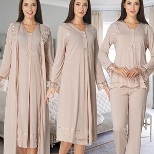 Puede incluir: Tres conjuntos de pijamas de color beige claro con ribetes de encaje. El primer conjunto es un camisón de manga larga con una bata a juego. El segundo conjunto es un camisón de manga larga. El tercer conjunto es una blusa de manga larga y pantalones a juego.