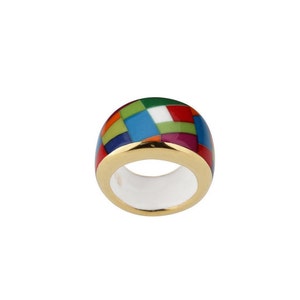 May include: A colourful ring with a gold band and a geometric pattern of red, green, blue, and purple enamel.