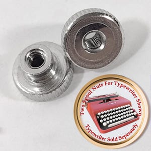 May include: Two silver spool nuts for a typewriter. The nuts have a knurled edge for easy grip and a threaded center. A circular graphic shows a red typewriter and text that reads "Two Spool Nuts For Typewriter Shown. Typewriter Sold Separately."