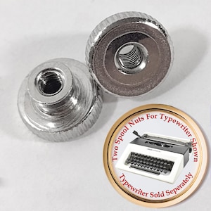 May include: Two silver spool nuts for a typewriter. The nuts have a knurled edge and a threaded center. The image also includes a circular graphic with a typewriter illustration and the text "Two Spool Nuts For Typewriter Shown. Typewriter Sold Separately."